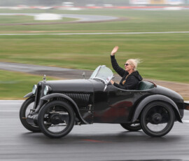 Michelle waving to the crowd along the main straight at a wet Winton Parade